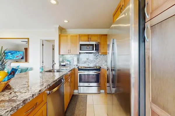 Bright kitchen showcases white cabinetry, stainless appliances, and organized counters