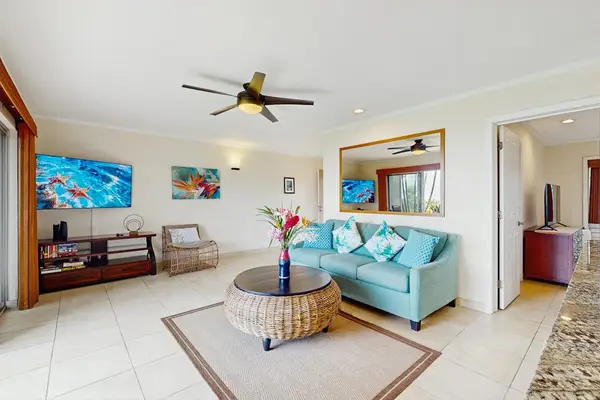 Sunlit living room features decor, comfortable seating, and ocean vistas