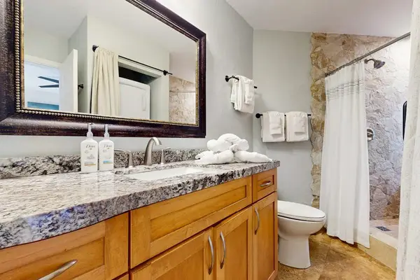 Modern bathroom features polished fixtures, bright mirrors, and fresh tiling