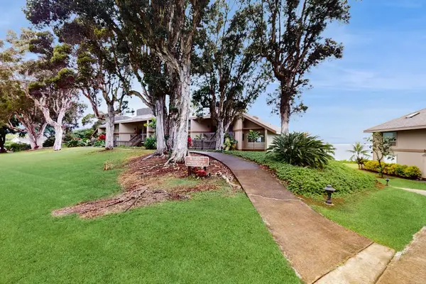 House exterior offers inviting details surrounded by greenery and lawns