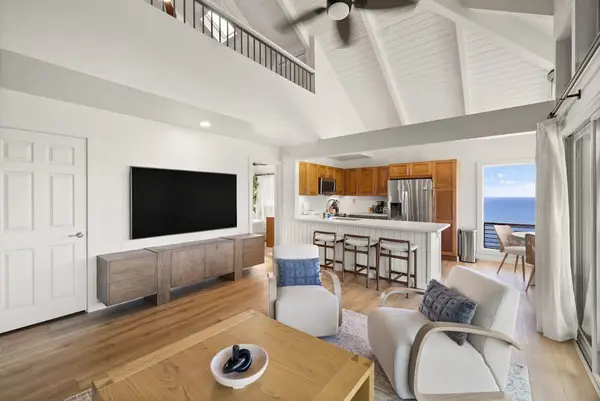 Bright living room with ocean views and a large TV