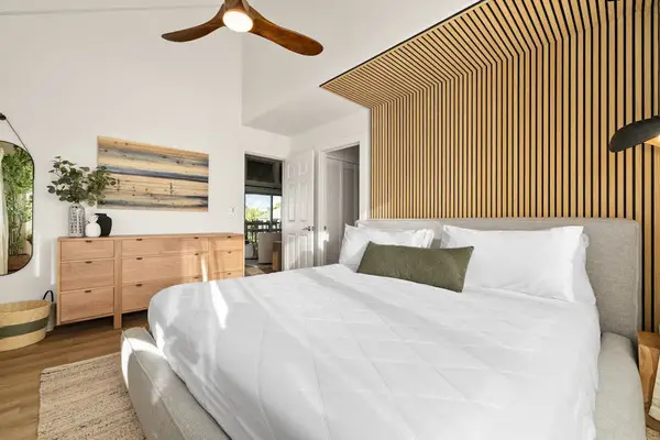 Comfortable bed with warm wood accents and neutral décor