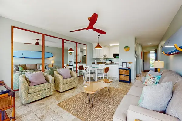 Cozy living room with surf-inspired décor, a flat-screen TV, a comfortable sofa bed, and direct access to the private lanai.