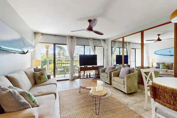 Cozy living room with surf-inspired décor, a flat-screen TV, a comfortable sofa bed, and direct access to the private lanai.