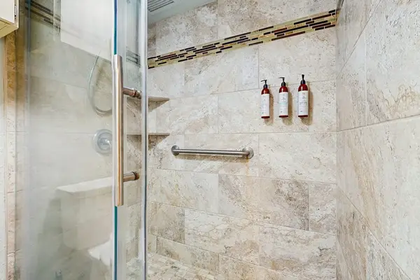 Bright, updated bathroom featuring a spacious tiled walk-in shower and modern finishes.