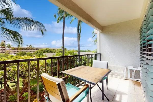 Private lanai with seating for two overlooking lush tropical paradise—perfect for morning coffee or sunset relaxation.