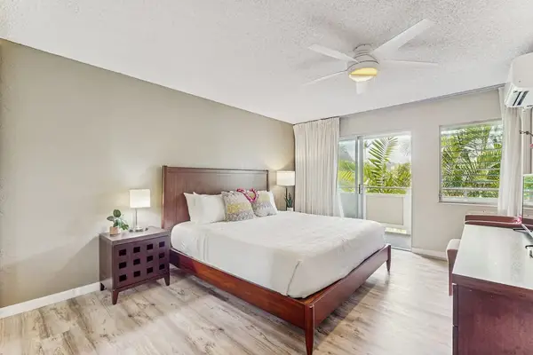 Newly remodeled condo with king bed, ceiling fan and light from the lanai.
