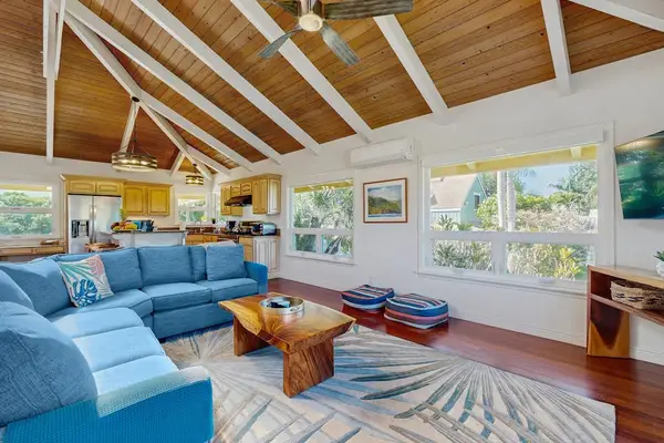 Bright, open living space with cathedral ceilings, skylights, Ipe wood floors, ceiling fans, A/C throughout, and seamless access to the lanai for effortless indoor-outdoor living and beautiful views.