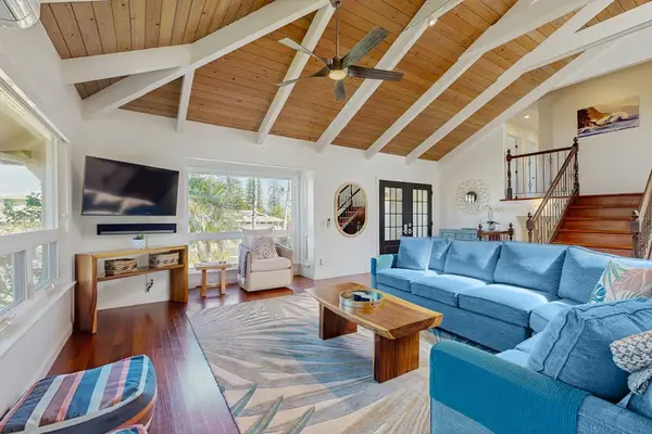 Bright, open living space with cathedral ceilings, skylights, Ipe wood floors, ceiling fans, A/C throughout, and seamless access to the lanai for effortless indoor-outdoor living and beautiful views.
