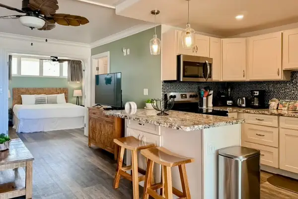 Modern kitchen showcases white cabinetry, stainless appliances, and tiled backsplash