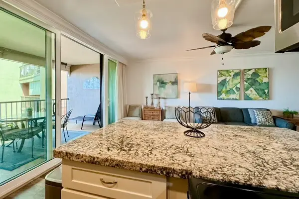 Bright kitchen features granite counters, modern appliances, and organized storage