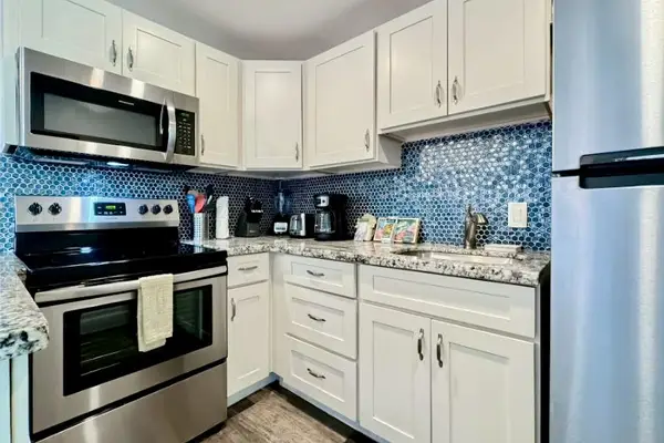 Updated kitchen presents granite surfaces, stainless appliances, and thoughtful storage
