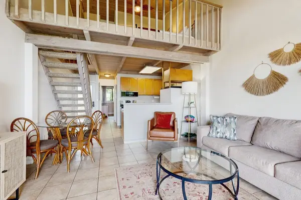 Living room with high ceilings and dining room table with seating for four.