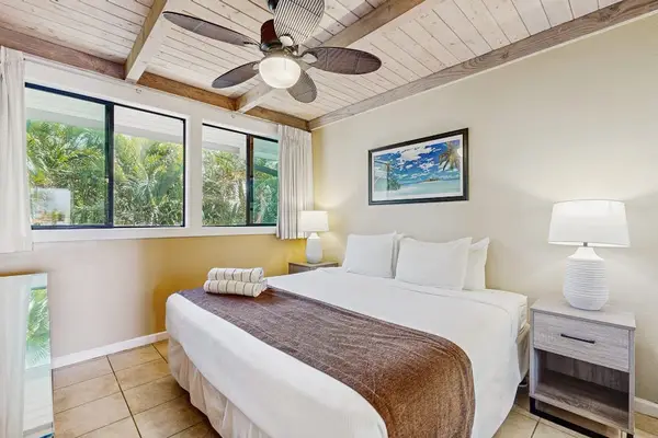 Master bedroom with king bed and ceiling fan.
