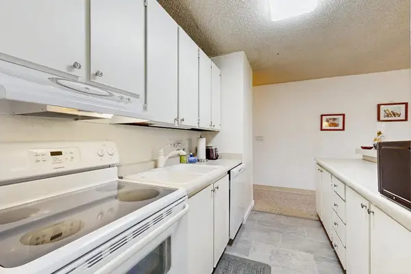 Kitchen Setup with Electric Range, Oven & White Cabinetry