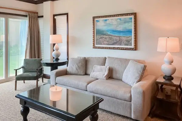 Bright living room with sliding glass doors, abundant natural light, and a comfortable sofa bed for extra guests.