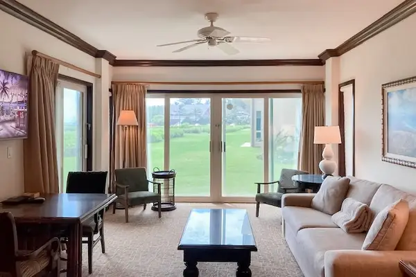 Bright living room with sliding glass doors, abundant natural light, and a comfortable sofa bed for extra guests with a flat screen TV.
