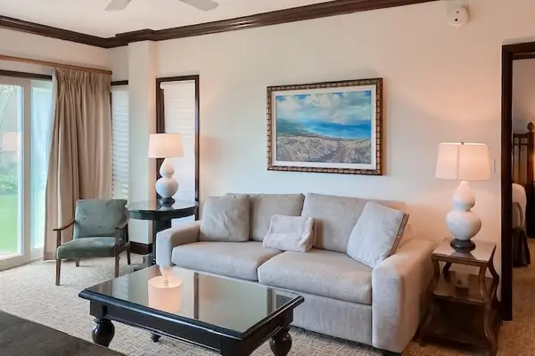 Bright living room with sliding glass doors, abundant natural light, and a comfortable sofa bed for extra guests.