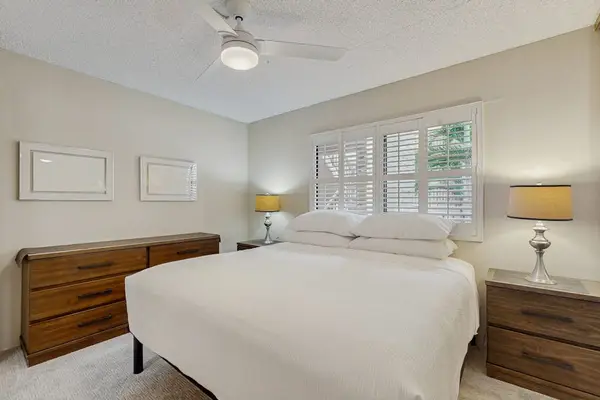Bright Bedroom with King Bed, Wooden Dresser & Shutter Blinds