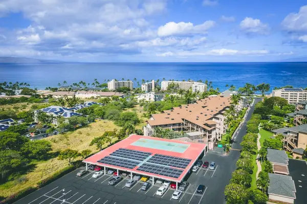 Stunning aerial view of the resort complex featuring the pool, tennis court, and ocean views