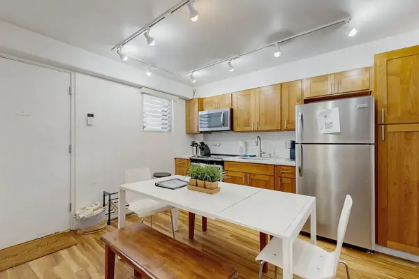 A bright and practical space featuring a dining area alongside a fully equipped kitchen for your convenience.