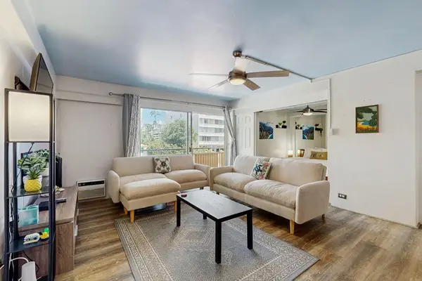 Relax in a stylish and comfortable living room featuring a ceiling fan for added airflow and comfort.
