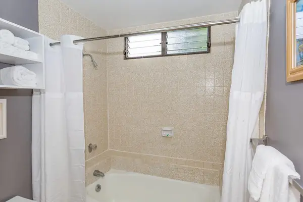 Full bathroom includes tiled soaking tub shower and folded towels