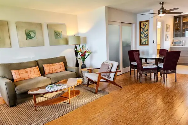 Comfortable living room flows into dining space beneath ceiling fans