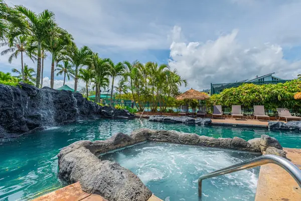 Relax poolside surrounded by tropical landscaping