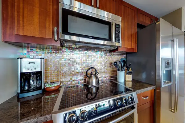 Fully equipped kitchen with everything you need for quick and delicious breakfasts, featuring a modern stove, microwave, coffee maker, and kettle to start your day right.