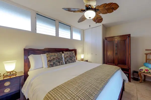 Bedroom, featuring a king bed, French doors, and a palm leaf fan.