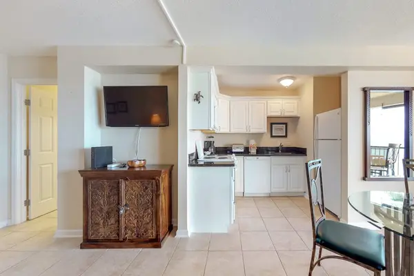 A fully equipped kitchen with a fridge, microwave, oven, and stovetop