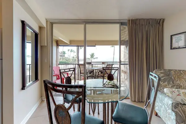 Dining area featuring a red-framed mirror and teal dining chairs