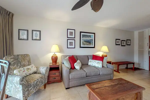 Living room featuring a brown sofa and a framed ocean scene.