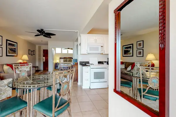 Dining area featuring a red-framed mirror and teal dining chairs