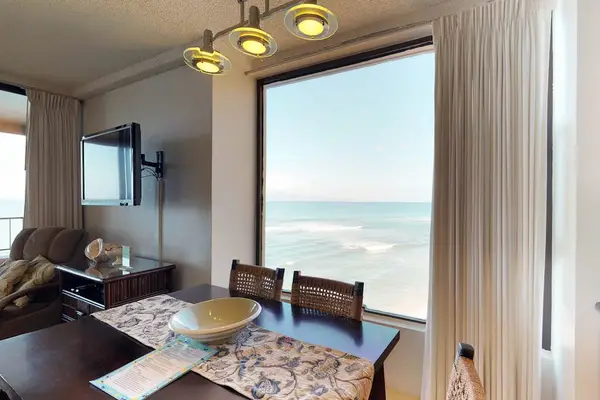 Dining room table for seating for five with a view out the window and the lanai.