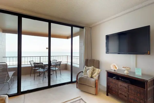Living room with a flat screen tv and open to the lanai.
