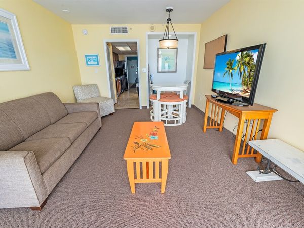 - Cozy and well-lit living space with a comfortable sofa and entertainment setup - Open layout connecting the living area to the dining and kitchen for convenience - Ideal for relaxing after a day at the beach or exploring local attractions