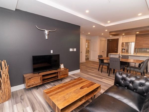 Unwind in the stylish living room with expansive skyline views. Settle into the cozy seating and enjoy your favorite shows on the Smart TV.