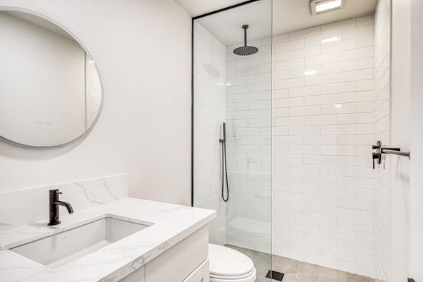 Pristine Modern Bathroom Featuring A Custom Subway Tile Shower