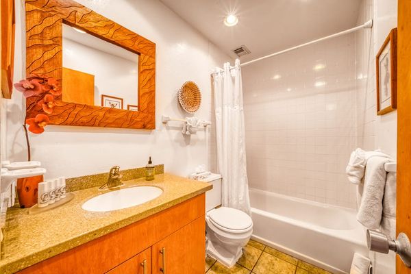 Spacious full bathroom featuring a single sink vanity, toilet, and clean shower/tub combo
