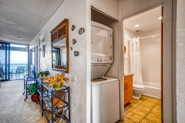 Convenient in-unit stacked washer and dryer located just outside the full guest bathroom