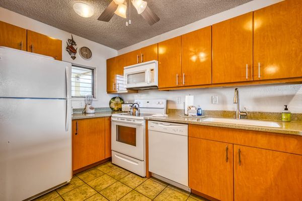 Fully functional kitchen featuring a refrigerator, stove, microwave, dishwasher, and plenty of cabinet storage