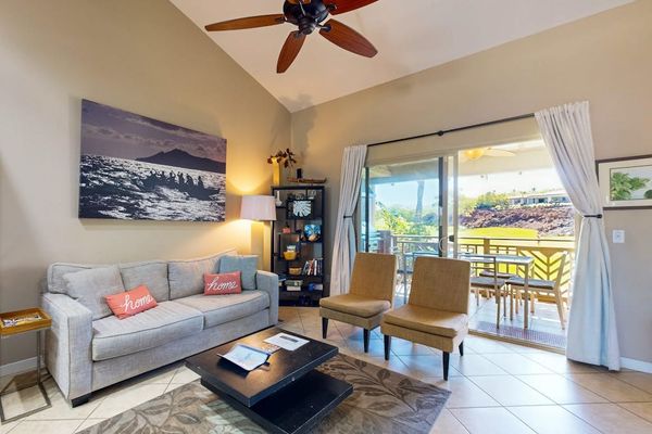 Living room with vaulted ceilings and large screen door for fresh air and natural light.