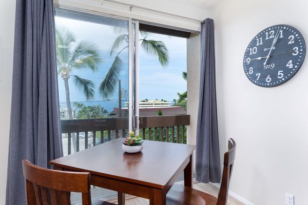 Wooden Table Seating, Wall Clock & Sliding Glass Balcony Access