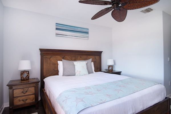 Guest bedroom with king bed and a ceiling fan for complete comfort.