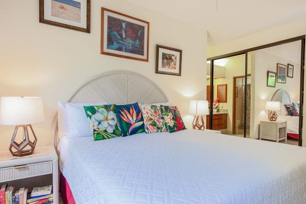 Plush King Bed Flanked by Nightstands & Mirrored Closet Doors