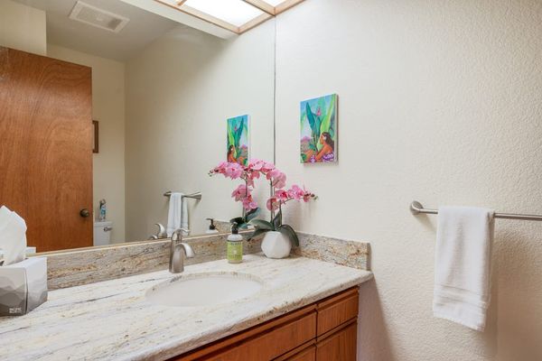 Spacious Bathroom Vanity with Granite Countertop & Warm Lighting