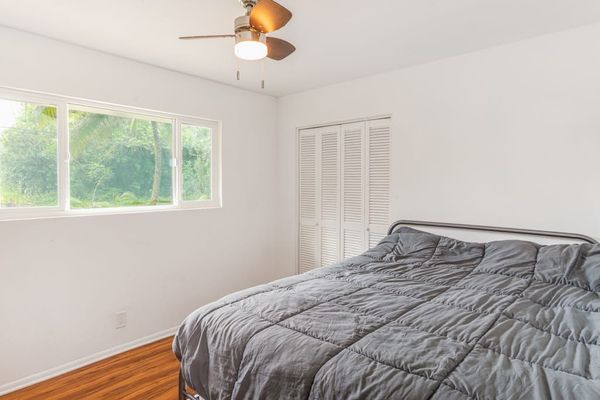 Master bedroom with queen bed and lots of light from the windows.