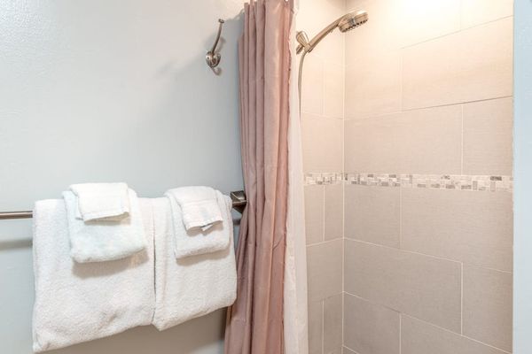 Bathroom Shower Area with Fresh Plush Towels and Curtains